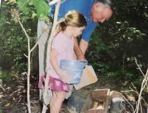 father and daughter filling bird feeder